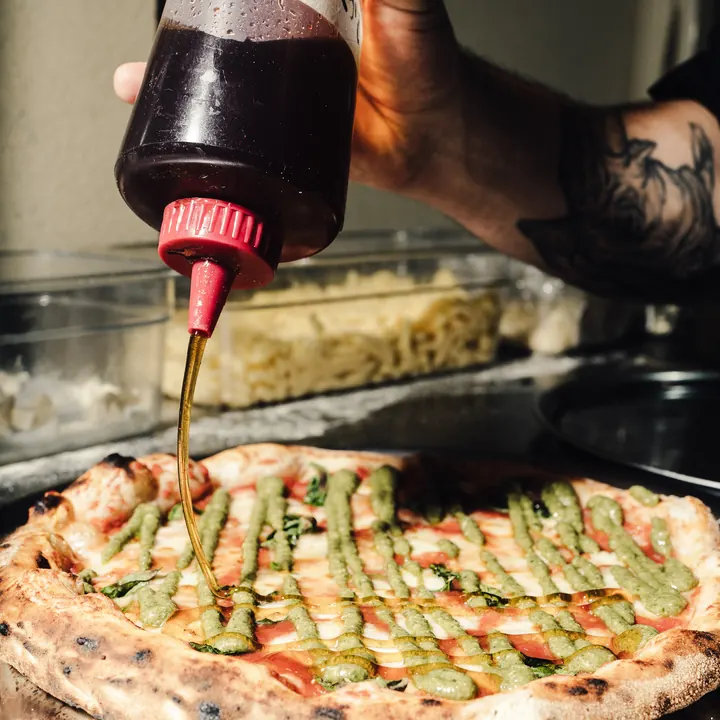 Miel picante sobre pizza de pesto
