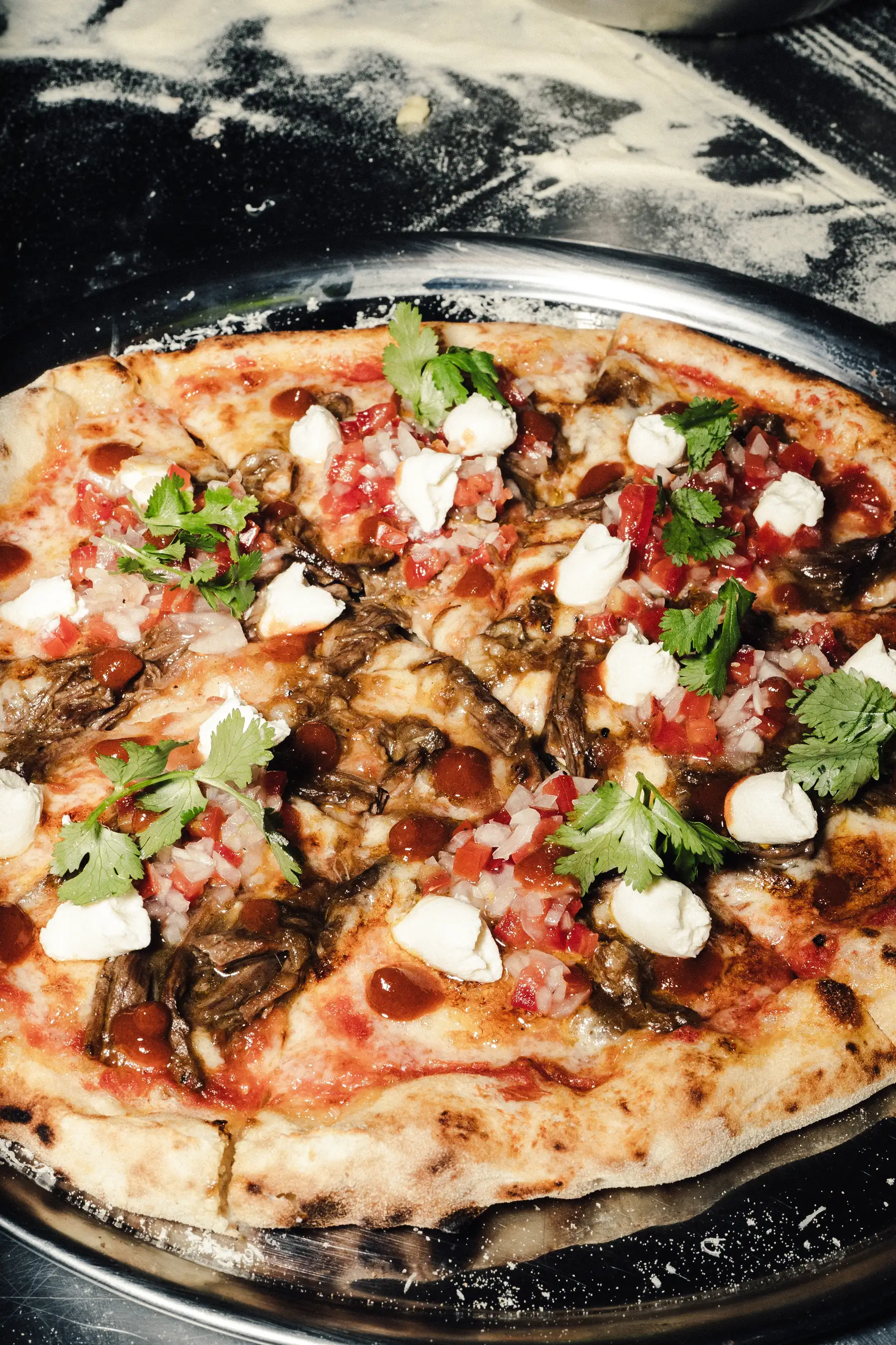 Pizza especial con crema, salsa y cilantro vista desde arriba