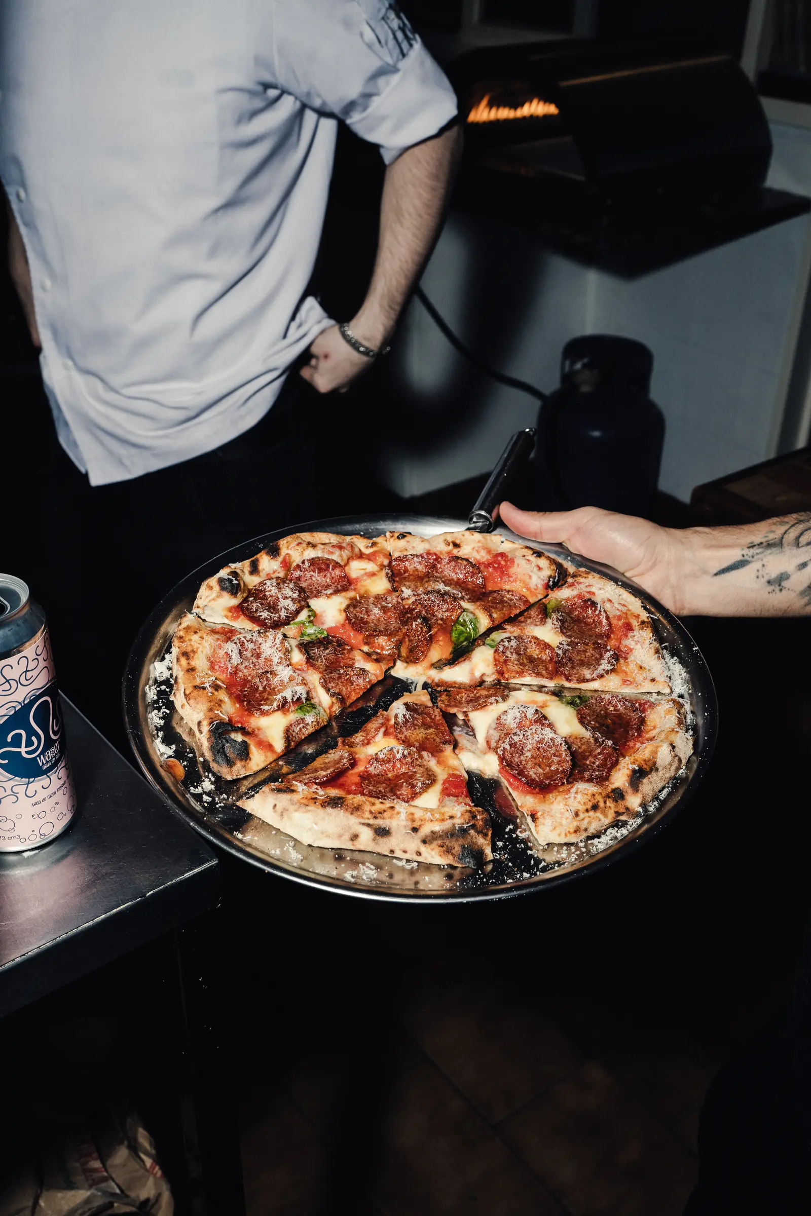 Pizza recién salida con las llamas del horno de fondo